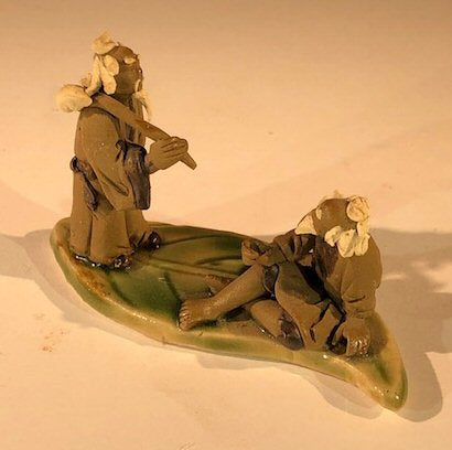 Miniature Ceramic Figurine  Two Mud Men On A Leaf, One Standing Holding a Bag, The Other Sitting - 2" - Culture Kraze Marketplace.com