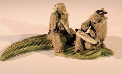Miniature Ceramic Figurine  Two Mud Men On A Leaf, One Sitting Holding a Fan, The Other Sitting With Musical Instrument- 2" - Culture Kraze Marketplace.com